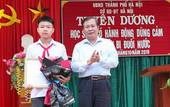 Phó Giám đốc Sở GD-ĐT Hà Nội Lê Ngọc Quang trao bằng khen của Chủ tịch UBND thành phố Hà Nội cho em Phan Trung Hiếu