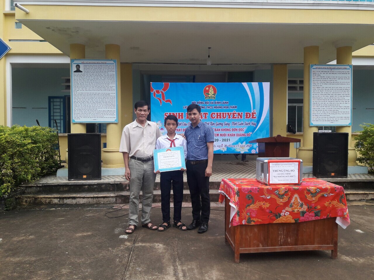 Thầy Nguyễn Tấn Tư - Hiệu trưởng và thầy Trương Hoàng Trọng Nguyên - TPT Đội trao tặng kinh phí hỗ trợ 'Em nuôi khăn quàng đỏ cho em Trần