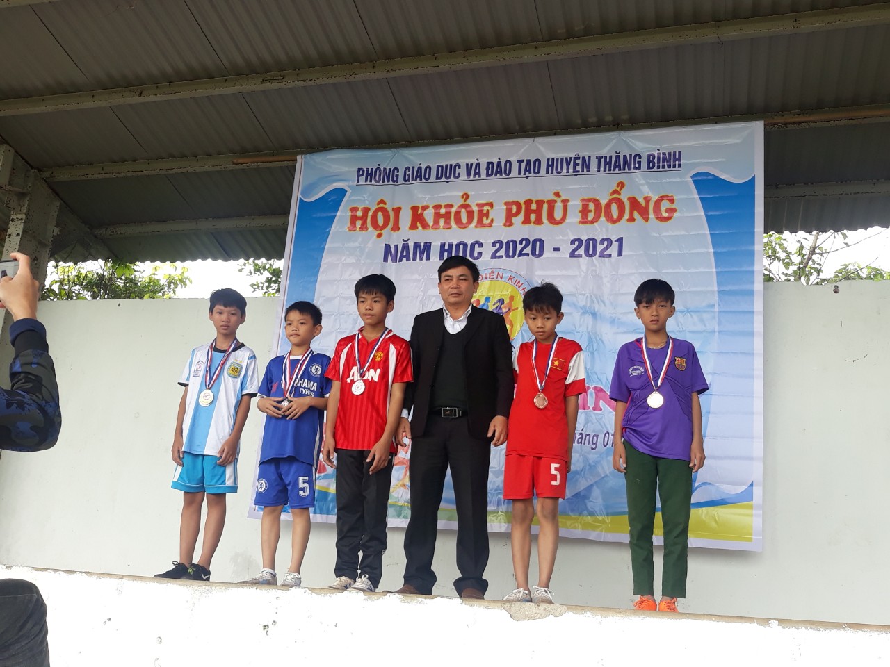 Thầy giáo Nguyễn Trường Quyền P. trưởng phòng GD trao huy chương cho các em có thành tích tốt